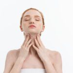 Reglare tiroidă natural ilustrată printr-o femeie care își atinge zona tiroidei