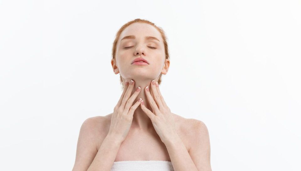 Reglare tiroidă natural ilustrată printr-o femeie care își atinge zona tiroidei